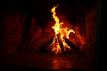 burning firewood in a brick fireplace/ fire in a brick fireplace