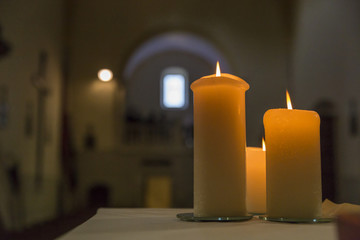 Three lighted candles inside a little church