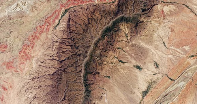 Very high-altitude overflight aerial of ridges and cropland in southern Uzbekistan. Clip loops and is reversible. Elements of this image furnished by USGS/NASA Landsat
