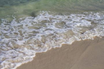 Sea water tide on white sand beach. Blue sea wave on smooth sand. Tropical seaside photo. Summer vacation
