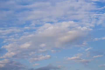 Blue sky and clouds in sunset light. Cloudscape photo background. Romantic skyscape with pink cloud.