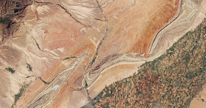 Very high-altitude overflight aerial of ridges and cropland in southern Uzbekistan. Clip loops and is reversible. Elements of this image furnished by USGS/NASA Landsat