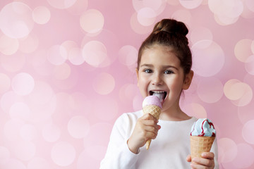 Happy child girl eating ice-cream in a crispy cone.