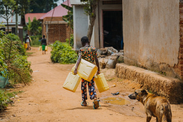 Child carrying water can in Uganda, Africa