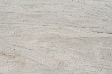 White sand beach texture. Sea coast top view photo. Natural texture. Smooth sand surface with sea wave mark.