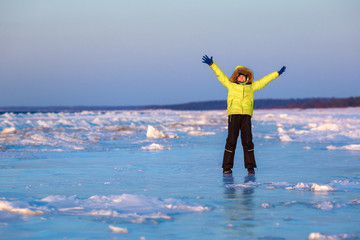 Cute little boy outdoors playing on frozen sea
