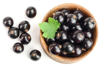 black currant with leaf in wooden bowl isolated on white background. Top view. Flat lay pattern