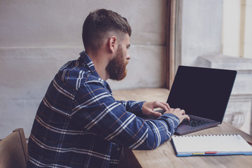 Young man chatting via net-book during work break in coffee shop