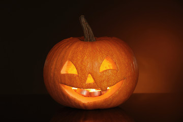 Halloween pumpkin head. Glowing jack lantern on dark background