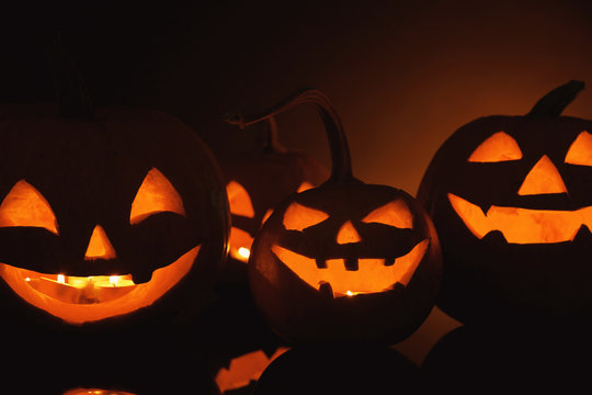 Halloween pumpkin heads. Glowing jack lanterns in dark