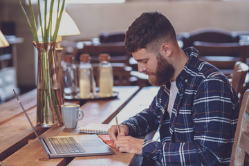 Fototapeta premium Casual business man or freelancer planning his work on notebook,