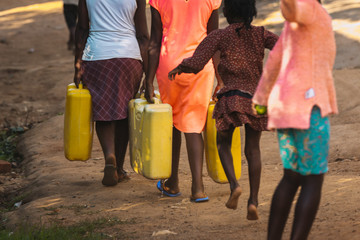 Women carrying water can in Uganda, Africa