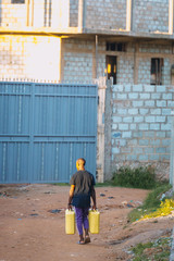 Man carrying water cans in Uganda, Africa