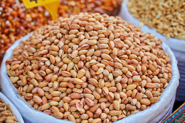 Pistachio, walnut, almond, , and nut in round metal trays in an authentic bazaar