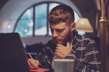 Casual business man or freelancer planning his work on notebook,