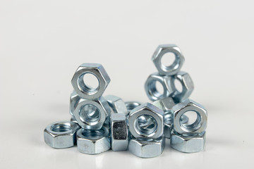 Chrome caps on a white table. Accessories for mounting steel structures on a workshop table.