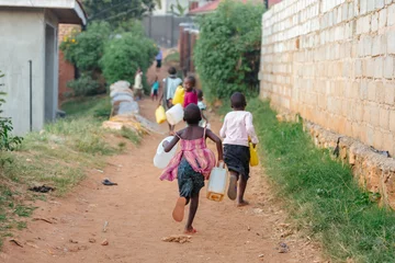 Fototapeten children carrying water cans in Uganda, Africa © Dennis