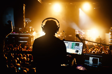 Club, disco DJ playing and mixing music for crowd of happy people. Nightlife, concert lights, flares