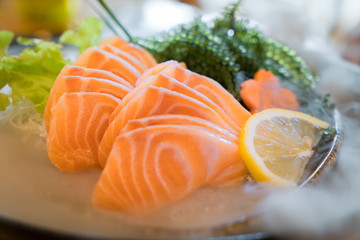 Raw salmon slice or salmon sashimi in Japanese style fresh serve on ice in bowl.