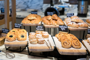 Breakfast lines of different flavor danishs, buns and muffins in wooden trays at the hotel restaurant