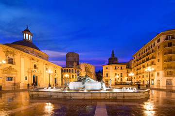 Fountain Rio Turia on Square of the Virgin Saint Mary, Valencia Cathedral, Basilica of Virgen the Helpless at night in Valencia, Spain..