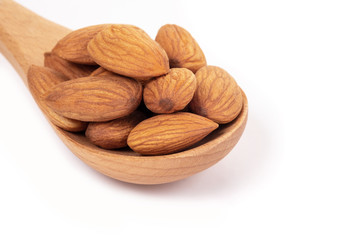 Almonds in wooden spoon on white background.
