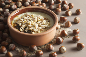 Baked rice pudding turkish milky dessert sutlac in earthenware casserole with hazelnuts