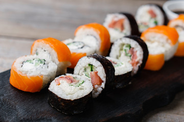 Restaurant menu, Japanese traditional food. Appetizing sushi rolls served on wooden tray