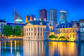 Travel Ideas. Binnenhof Palace of Parliament in The Hague in The Netherlands at Blue Hour. Against Modern Skyscrapers.