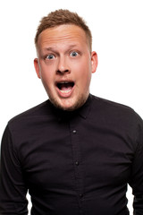 Vertical shot of stupefied stunned shocked young male keeps mouth widely opened, being surprised and very emotional, expresses great surprisment.