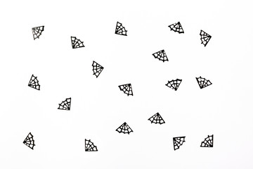 Spiderweb confetti on the white background. Halloween party concept. Flat-lay, top view.