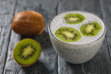 Kiwi fruit and a glass bowl of Chia seeds with milk on the village table.