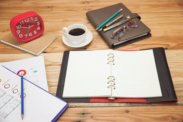 Top view of office desk with paper, stationery and analysis chart.