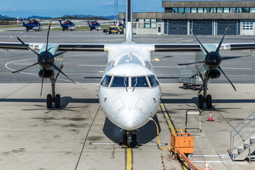 An aircraft twin turboprop parked next to a jetway at Bergen International Airport, Norway.