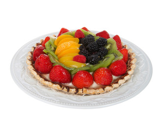 Fresh custard filled tart on a plate with fresh fruit, strawberries, kiwi, peaches, blackberries and raspberries, isolated on white background. Delicious healthy dessert option.