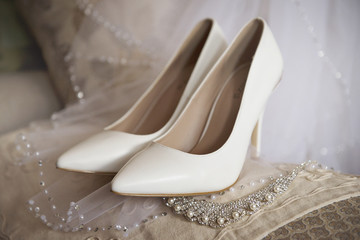 Obraz na płótnie Canvas Wedding bridal shoes in the interiors close-up in beige tones.The collection of the bride.