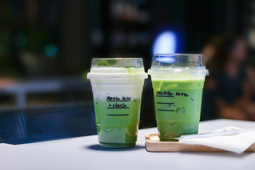 Iced matcha green tea latte on table in store.