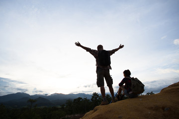 Obraz premium Silhouette of hikers standing on top of hill and enjoying sunrise over the valley
