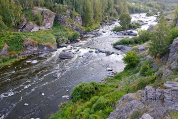 river with rapids and rocky slopes landscape of a summer sunset, the Urals