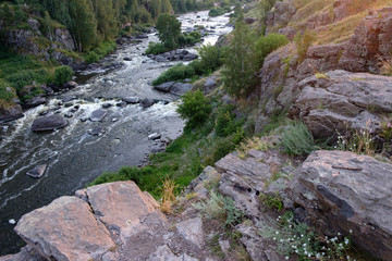 stone plateau from which you can see the fast running river Iset, the landscape of the river with rapids