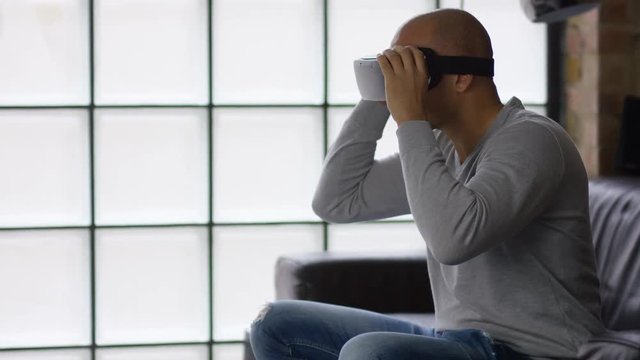 Young mixed race man putting on a virtual reality headset