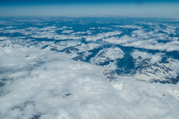 White heavy clouds in the blue sky. Panoramic cloudscape above the clouds.