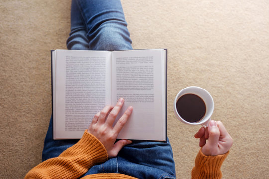 Reading Concept. Soft Focus of  Young Woman Relaxing by Book and Coffee in Cozy House, Sit on the Floor, Top View - Powered by Adobe