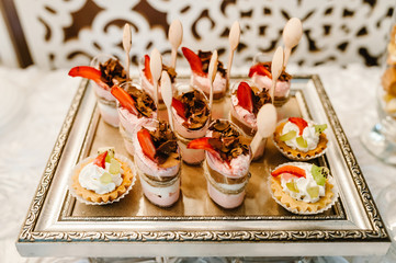 Panna cotta with orange and mint, jelly topping with strawberry sauce. traditional italian dessert. Decorated delicious table for a party goodies.