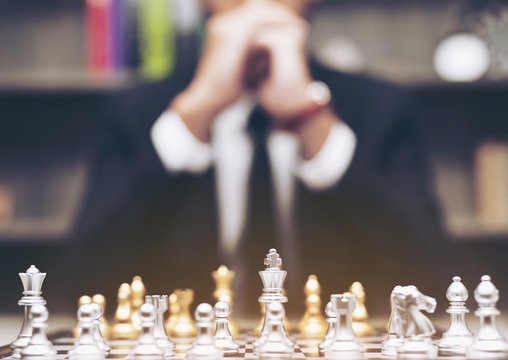 Businessman with clasped hands planning strategy play with chess game. ,blur. concept of business strategy and tactic to success