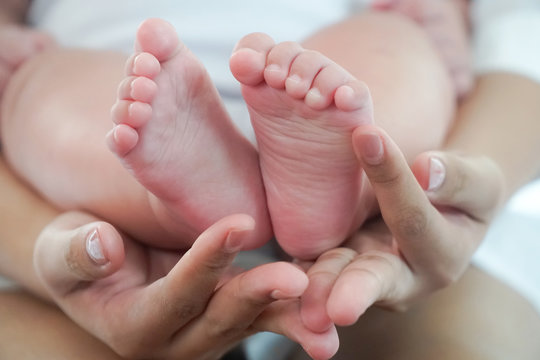 Close up of Baby feet in mother hands.  Mom and her Child. Beautiful conceptual image of maternity or happy family time together concept