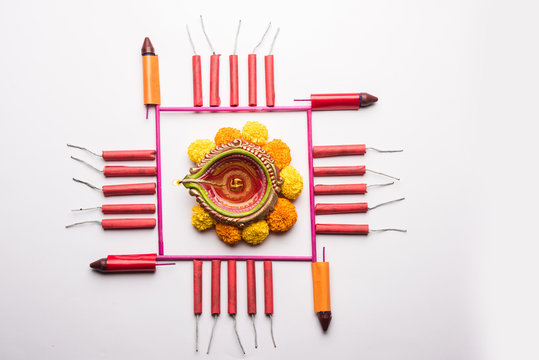 Diwali Firecrackers along with Clay oil lamp or Diya arranged over white background to create a beautiful rangoli or design