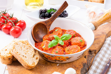 Baked mini meatballs in tomato sauce with basil