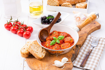 Baked mini meatballs in tomato sauce with basil