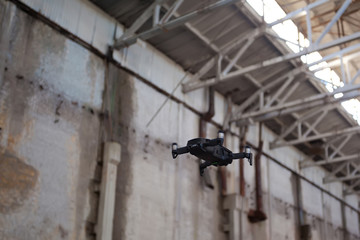 Quad-copter drone with camera flying inside industrial building